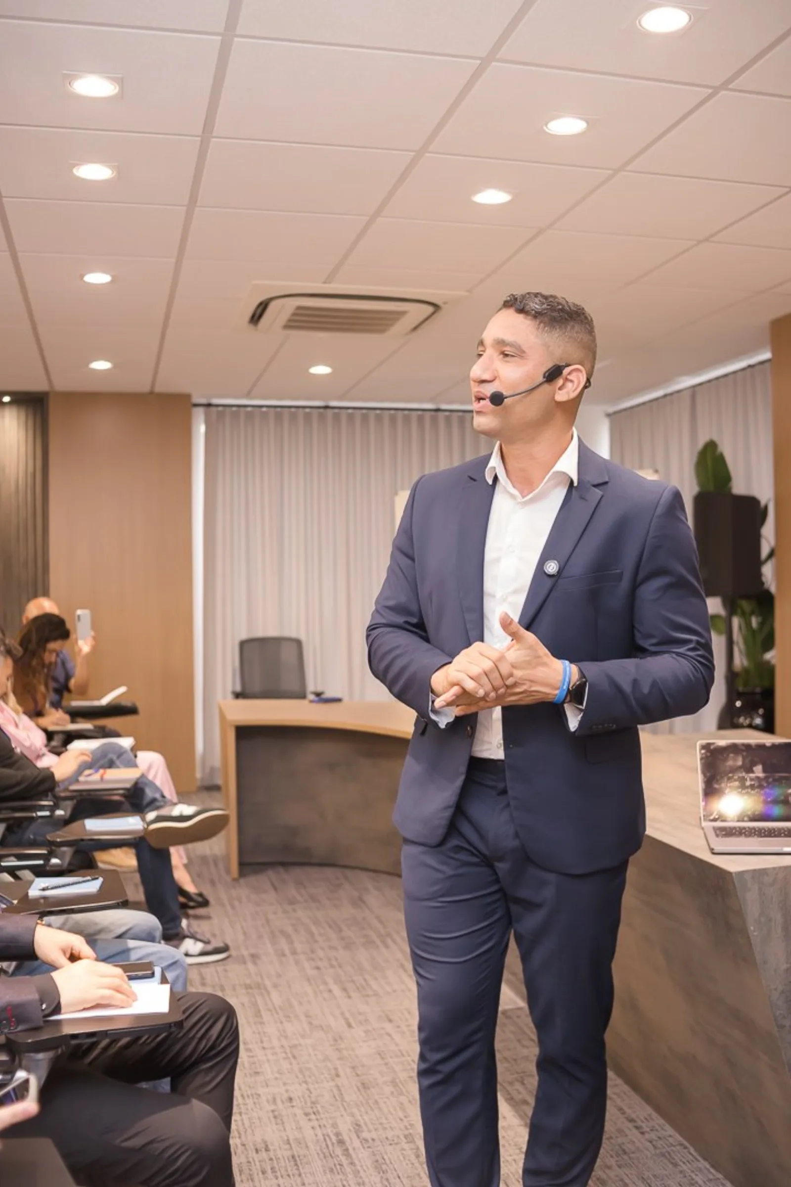 Lúcio Artes conduzindo treinamento presencial em sala corporativa.